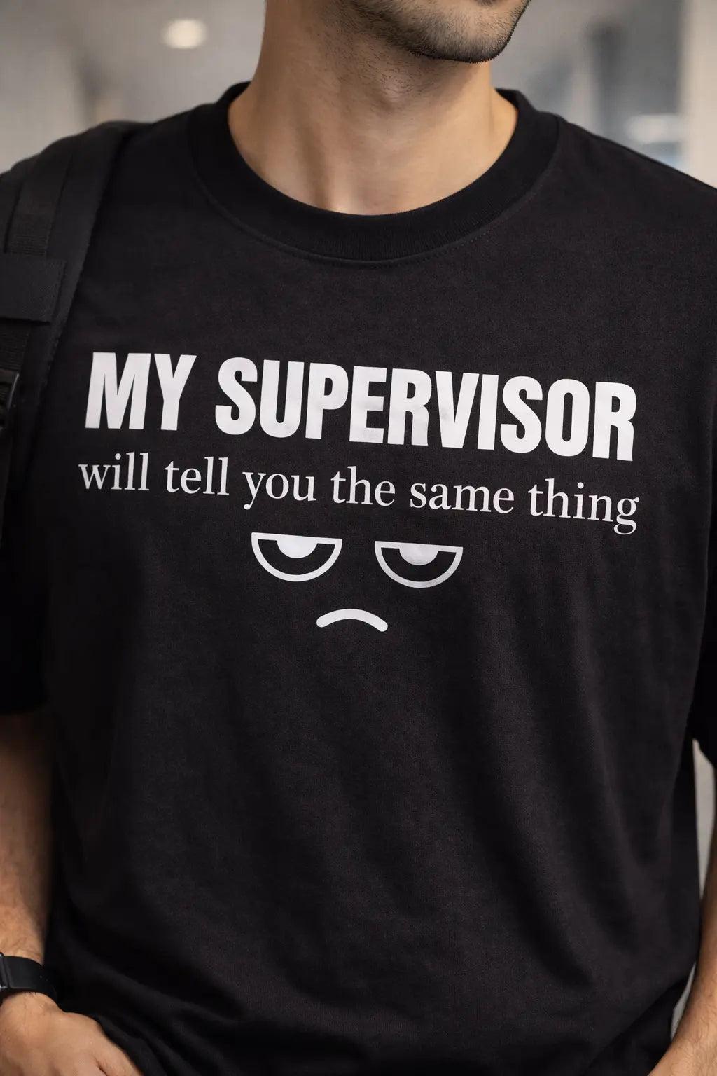 Person wearing a black t-shirt with humorous text and emoji design.