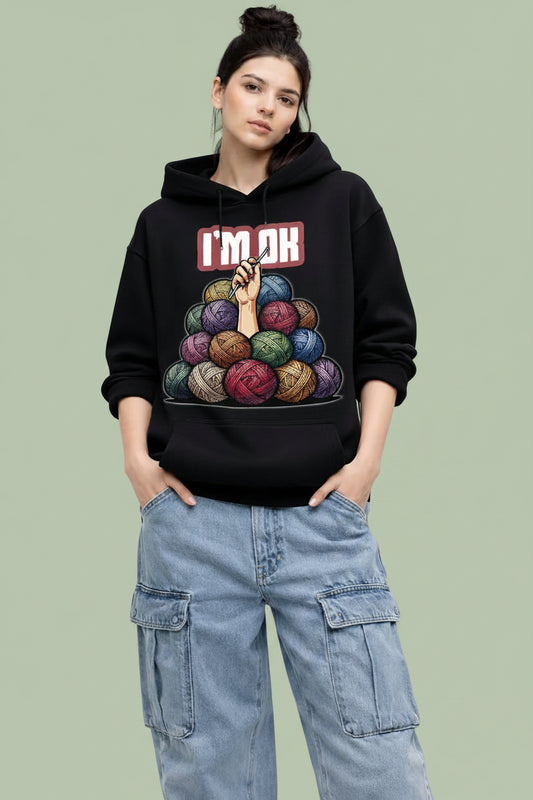 Person wearing a black premium oversized hoodie with colorful graphic design and text,  