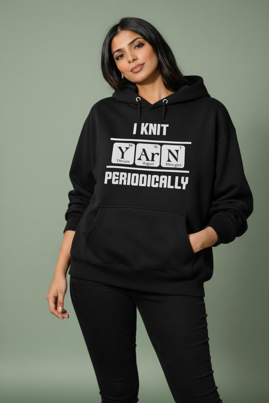 Person wearing a black oversized hoodie with text in a yarn store
