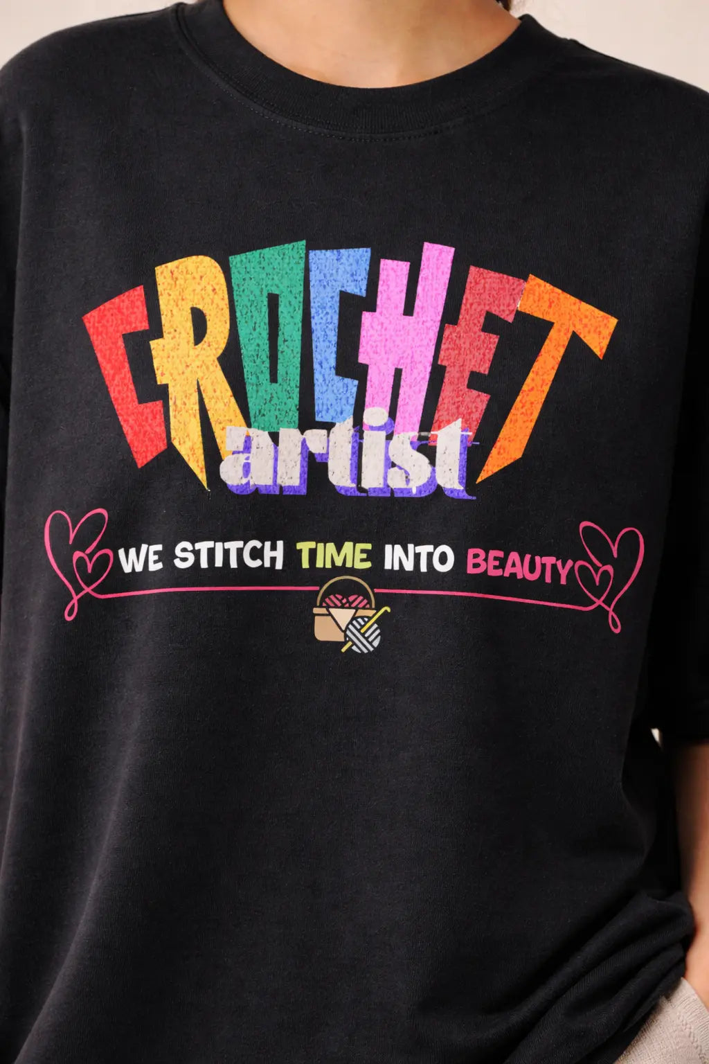 Black oversized t-shirt with colorful 'Crochet artist' text and additional design elements.