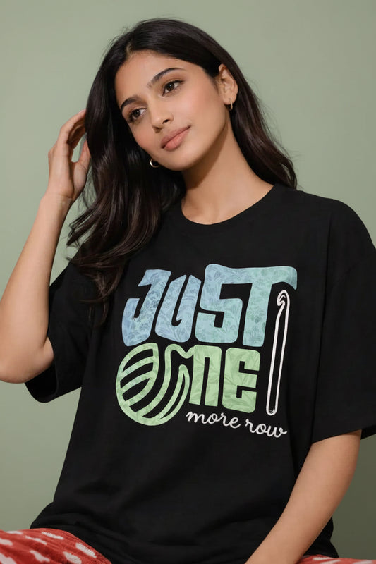 Woman wearing a black oversized  t-shirt with 'Just One More Row' text and graphic.