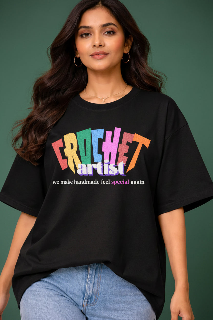 a person wearing a black premium oversized t-shirt with colorful text  